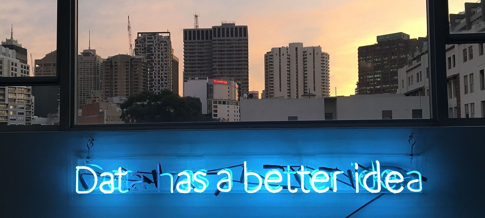 Blaue leuchtende Schrift vor einer City Skyline